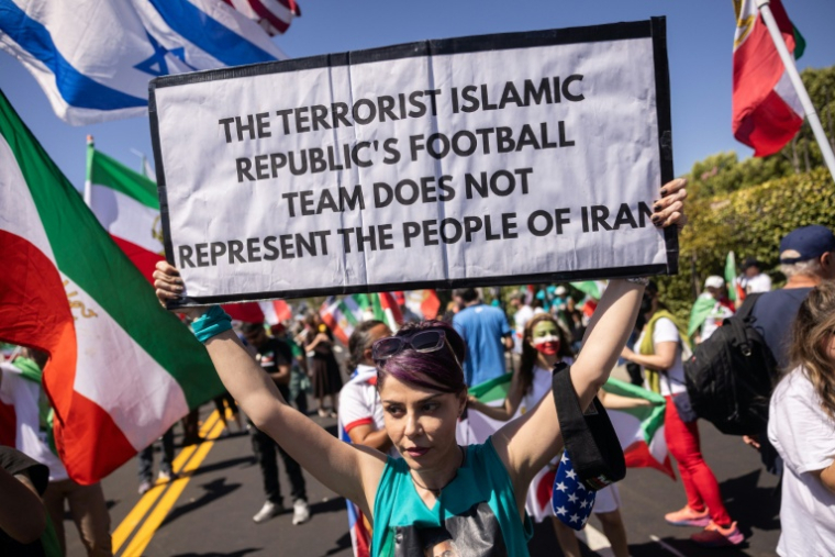 Une manifestante brandit une pancarte assurant que l'équipe de football d'Iran "ne représente pas le peuple", près du SoFi Stadium à Inglewood, près de Los Angeles, le 15 juin 2026 ( AFP / ETIENNE LAURENT )