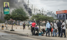 Des manifestants aident l'un d'entre eux, blessé, près de barricades en feu, le 29 octobre 2025 à Dar es Salaam, capitale économique de la Tanzanie ( AFP / - )