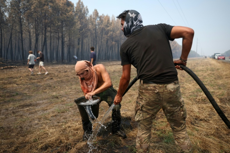 Un volontaire remplit un seau d’eau pour aider à lutter contre l’incendie dans une forêt à Lanton, à l’ouest de Bordeaux, le 29 juillet 2026, lors des feux de forêt dans le département de la Gironde, dans le sud-ouest de la France ( AFP / ROMAIN PERROCHEAU )