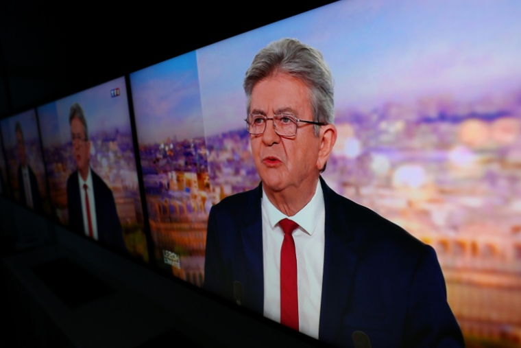 L'image du leader de LFI Jean-Luc Mélenchon affichée sur des écrans alors qu'il officialise sa candidature pour la présidentielle de 2027 sur le plateau de TF1, le 3 mai 2026 ( AFP / Kiran RIDLEY )