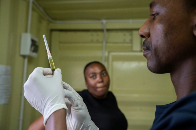 Kegoratile Aphane (G) attend une injection de lenacapavir, traitement empêchant la transmission du VIH, à la clinique Phedisong de Ga-Rankuwa, un township des environs de Pretoria, le 2 décembre 2025 ( AFP / Ihsaan Haffejee )