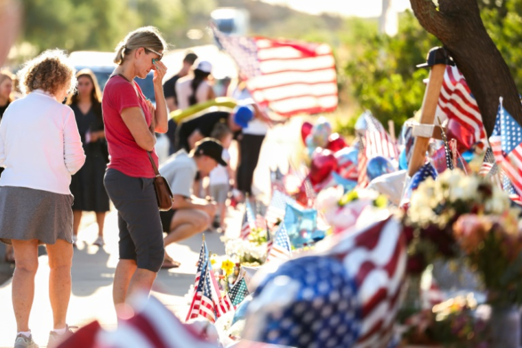 Des personnes se recueillent devant un mémorial improvisé en hommage à l'influenceur conservateur Charlie Kirk, le 14 septembre 2025 à Phoenix, en Arizona ( AFP / CHARLY TRIBALLEAU )