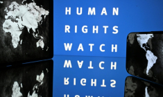 Le logo de l'ONG Human Rights Watch et une carte du monde, à Toulouse, le 16 juin 2025 ( AFP / Lionel BONAVENTURE )