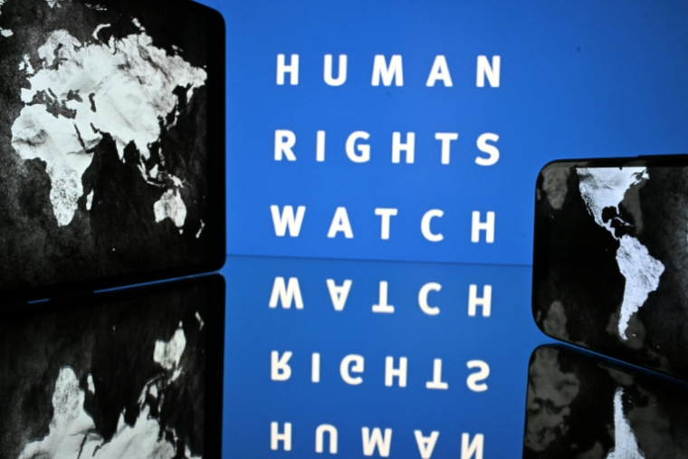 Le logo de l'ONG Human Rights Watch et une carte du monde, à Toulouse, le 16 juin 2025 ( AFP / Lionel BONAVENTURE )