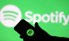 Un smartphone devant un écran projetant le logo de Spotify