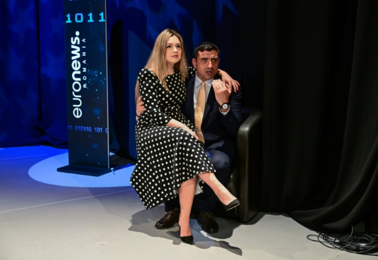 Le candidat à la présidence romaine George Simion et sa femme Ilinca, à l'occasion d'un débat télévisé le 8 mai 2025 à Bucarest ( AFP / Daniel MIHAILESCU )