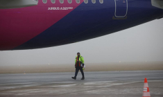 Un agent d'assistance au sol marche sur le tarmac près d'un Airbus A321neo de Wizz Air, immatriculé 9H-WMI, à l'aéroport de Varsovie-Modlin à Modlin.