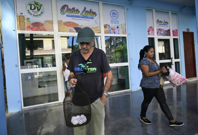 Des personnes sortent avec leurs courses d'un marché de quartier" à La Havane, le 5 octobre 2026 à Cuba ( AFP / YAMIL LAGE )