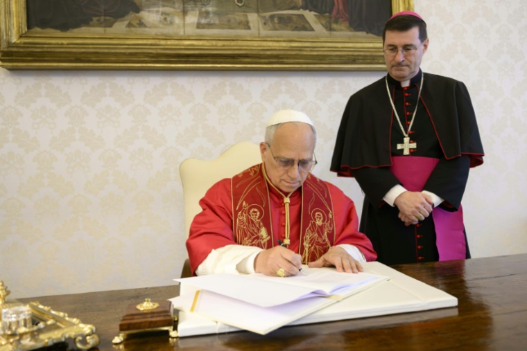 Photo, prise le 15 mai 2026 et diffusée le 25 mai 2025 par The Vatican Media, montre le pape Léon XIV en train de signer au Vatican sa première lettre encyclique, "Magnifica Humanitas", consacrée à l'essor de l'intelligence artificielle ( VATICAN MEDIA / Handout )
