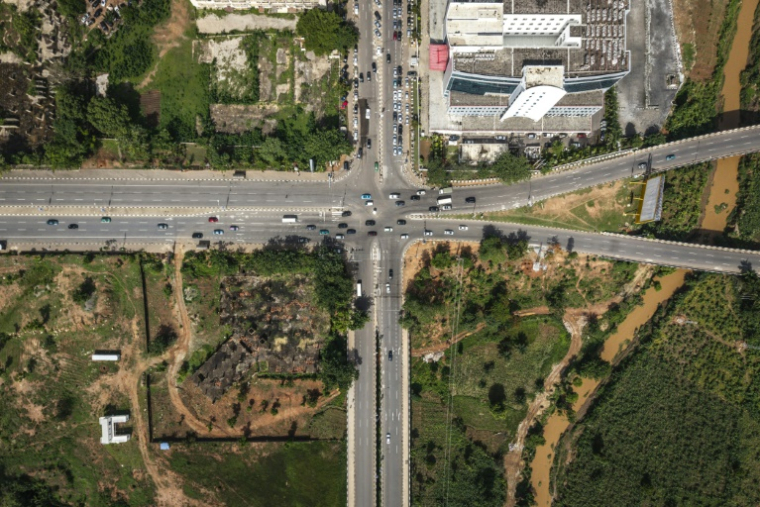 Vue aérienne de fermes urbaines traversées par des ponts autoroutiers dans le quartier d'affaires d'Abuja, le 23 mai 2025 au Nigeria ( AFP / OLYMPIA DE MAISMONT )