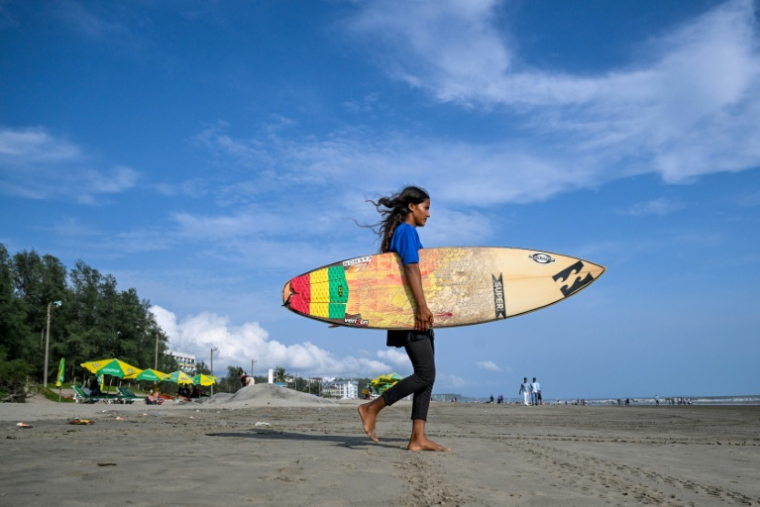 La surfeuse bangladaise Fatima Akhter sur la plage de Cox's Bazar, dans le sud-est du Bangladesh, le 19 juin 2026   ( AFP / Munir UZ ZAMAN )