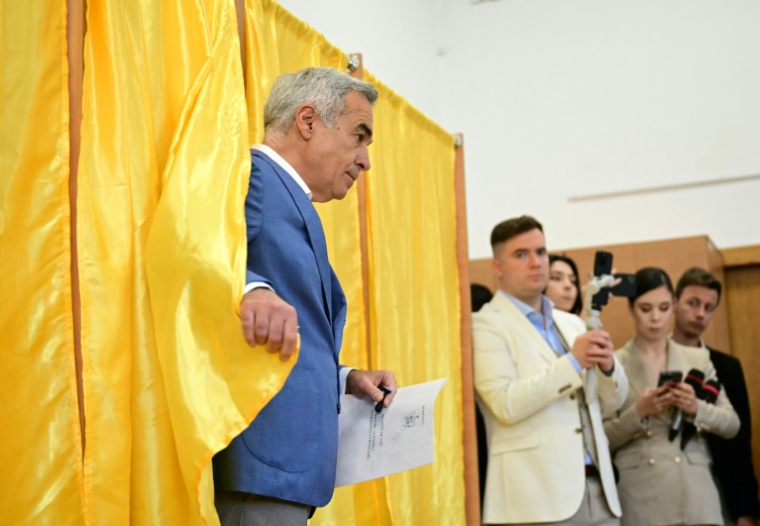 Calin Georgescu, ex-candidat à la présidentielle roumaine, vote au premier tour de l'élection à Mogosoaia, le 4 mai 2025 ( AFP / Daniel MIHAILESCU )