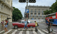 Des piétons traversent devant un feu de signalisation éteint en raison d'une panne d'électricité dans une rue de La Havane, le 3 décembre 2025 ( AFP / ADALBERTO ROQUE )
