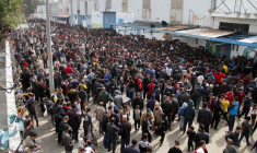 Des Palestiniens se rassemblent pour recevoir de l'aide devant un entrepôt de l'UNRWA dans la ville de Gaza