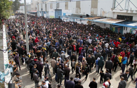 Des Palestiniens se rassemblent pour recevoir de l'aide devant un entrepôt de l'UNRWA dans la ville de Gaza
