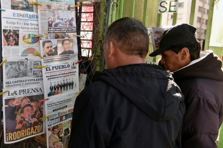 Des hommes lisent les unes des journaux sur l'élection présidentielle dans un kiosque à La Paz, le 18 août 2025 en Bolivie ( AFP / JORGE BERNAL )