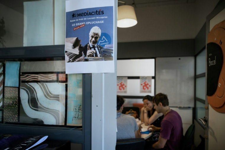 Des journalistes de Mediacités et des bénévoles examinent des notes de frais établies lorsque Laurent Wauquiez (LR) était président de la région Auvergne-Rhône-Alpes, dans les locaux de Mediacités à Lyon, le 18 juin 2026 ( AFP / Jeff PACHOUD )