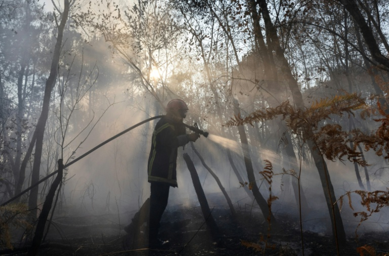 Un pompier lutte contre un incendie à Saint-Just, au sud de Rennes, le 13 août 2026  ( AFP / Fred TANNEAU )