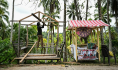 Un homme reconstruit un abri à Manay après deux puissants séismes dans le sud des Philippines, le 11 octobre 2025 ( AFP / Jam STA ROSA )