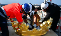 Des ouvriers remettent en place la couronne dorée de la statue de la Bonne Mère, à Marseille, le 17 octobre 2025 ( AFP / Christophe SIMON )