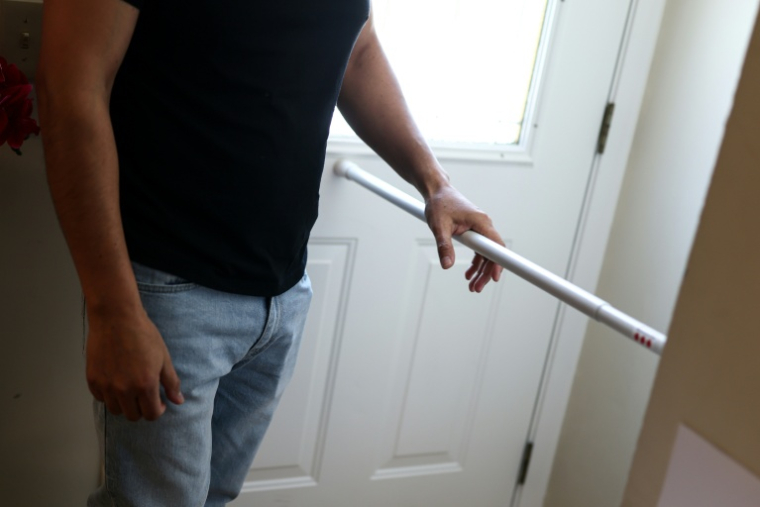 Carlos, un habitant mexicain de Minneapolis, montre la barre de métal qu'il a installée devant sa porte d'entrée, le 31 janvier 2026, alors que la ville est le théâtre depuis plusieurs semaines de raids de la police de l'immigration (ICE) ( AFP / CHARLY TRIBALLEAU )