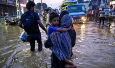 Une femme portant un enfant traverse une rue inondée après de fortes pluies à Wellampitiya, au Sri Lanka, près de Colombo, le 30 novembre 2025 ( AFP / Ishara S. KODIKARA )
