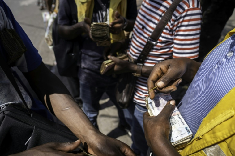 Des billets rwandais et congolais dans les mains de changeurs à Goma, en RDC, le 14 janvier 2026 ( AFP / Glody MURHABAZI )