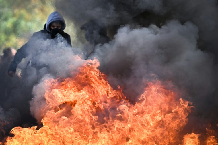 Un manifestant devant une barricade en feu pendant la mobilisation lycéenne devant le lycée Le Corbusier à Aubervilliers, en Seine-Saint-Denis, le 1er octobre 2026 ( AFP / LOU BENOIST )