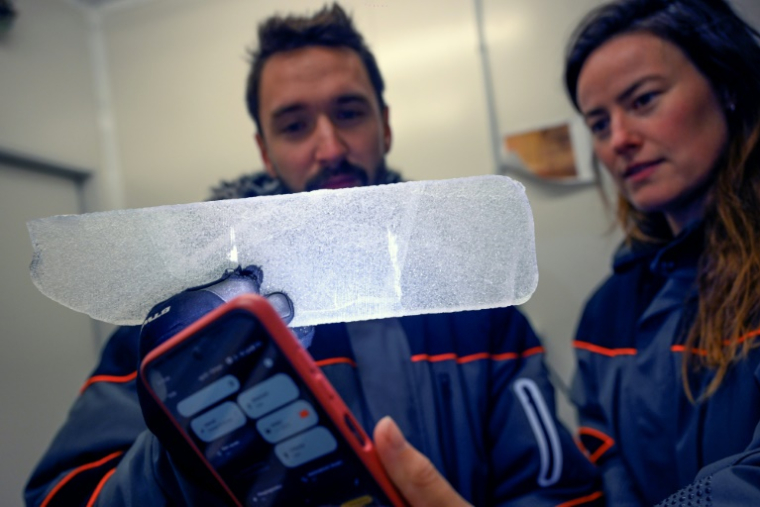 Des scientifiques examinent une carotte glaciaire antarctique dans un laboratoire à Bruxelles, le 15 juillet 2025 en Belgique ( AFP / Nicolas TUCAT )