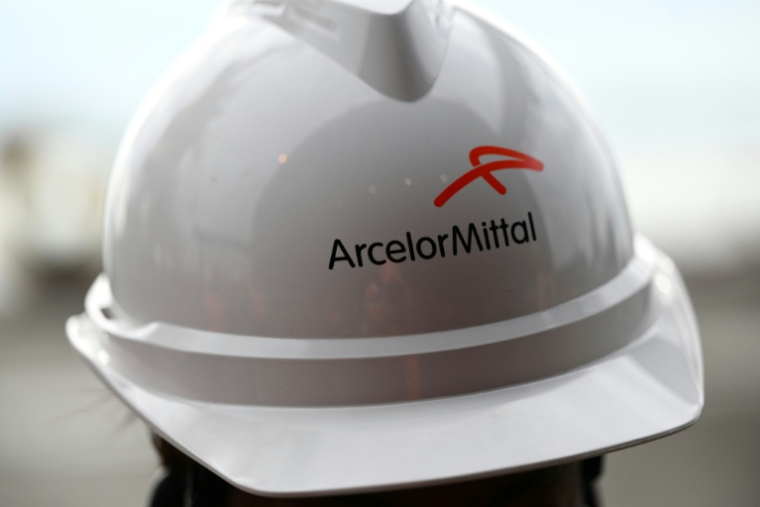 Un employé porte un casque comportant le logo d'ArcelorMittal, à Fos-sur-mer, le 22 février 2023 ( AFP / Christophe SIMON )