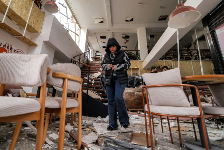 Le personnel d'un café constate les dégâts après une frappe de missile, à Téhéran le 29 mars 2026 ( AFP / ATTA KENARE )