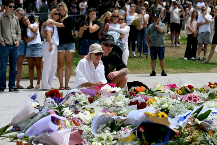 Des personnes se recueillent après l'attentat de la plage de Bondi, le 15 décembre 2025 à Sydney ( AFP / Saeed KHAN )