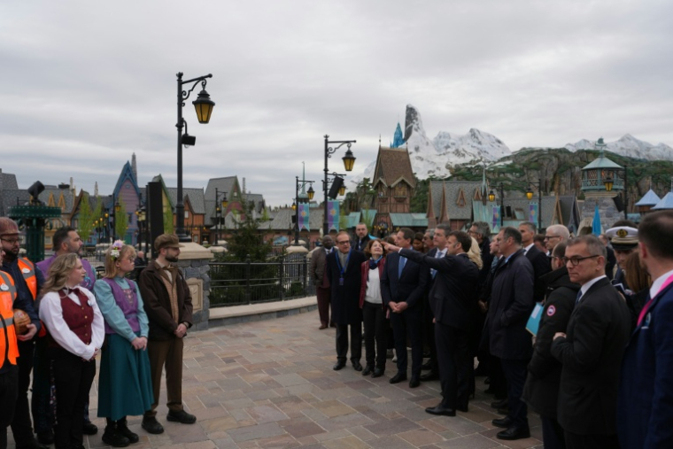 Le président Emmanuel Macron (au centre) à l'inauguration du nouveau parc à thème « Le Monde de La Reine des neiges » à Disneyland Paris, à Marne-la-Vallée, à l'est de Paris, le 27 mars 2026. ( POOL / Thibault Camus )