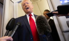 Le président américain Donald Trump parle à la presse, avec son ministre de la Défense Pete Hegseth dans son dos, à bord de l'avion présidentiel Air Force One en direction de Miami, le 7 mars 2026 ( AFP / SAUL LOEB )