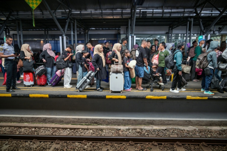 Des voyageurs attendent le train pour regagner leurs villes natales pour la fête de l'Aïd, le 17 mars 2026 à Subaraya, en Indonésie ( AFP / JUNI KRISWANTO )