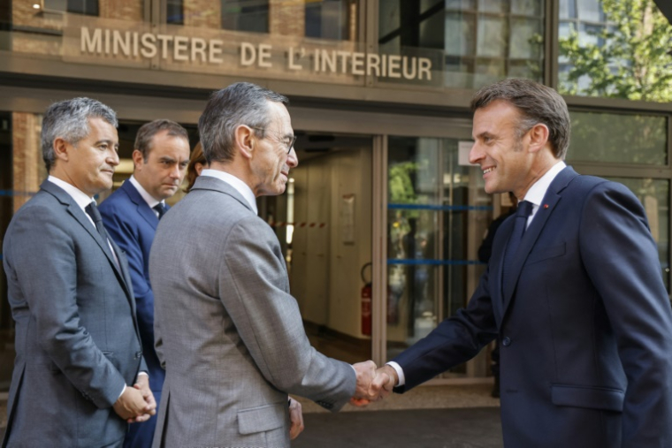 Le président de la République Emmanuel Macron (à droite) et le ministre de l'Intérieur Bruno Retailleau se serrent la main, le 14 mai 2025 à Nanterre, près de Paris ( POOL / LUDOVIC MARIN )