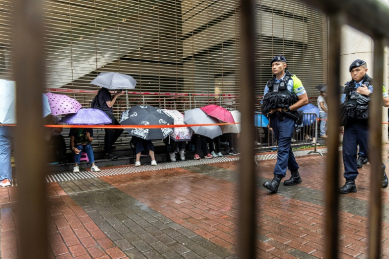 Des policiers devant le tribunal de West Kowloon avant l'arrivée du magnat des médias Jimmy Lai pour son procès à Hong Kong, le 18 août 2025 ( AFP / ISAAC LAWRENCE )