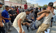 Des Palestiniens transportent un homme blessé près un centre d'aide de Kahn Youès dans le territoire de Gaza; me 17 juin 2025. ( AFP / - )
