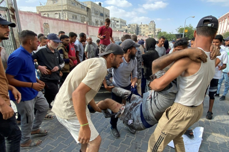 Des Palestiniens transportent un homme blessé près un centre d'aide de Kahn Youès dans le territoire de Gaza; me 17 juin 2025. ( AFP / - )
