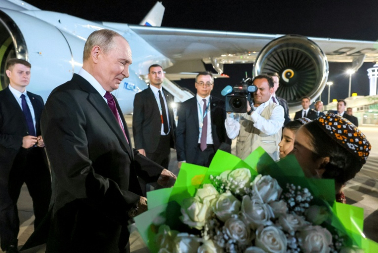 Des enfants accueillent le président russe Vladimir Poutine à sa descente d'avion, le 8 octobre 2026 à Turkmenbashi au Turkménistan ( POOL / Vladimir SMIRNOV )