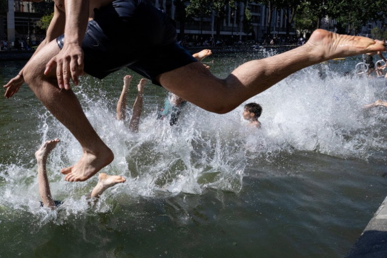 Des jeunes sautent dans le Bassin des Recollets sur le canal Saint-Martin, le 17 juin 2026 à Paris ( AFP / JOEL SAGET )