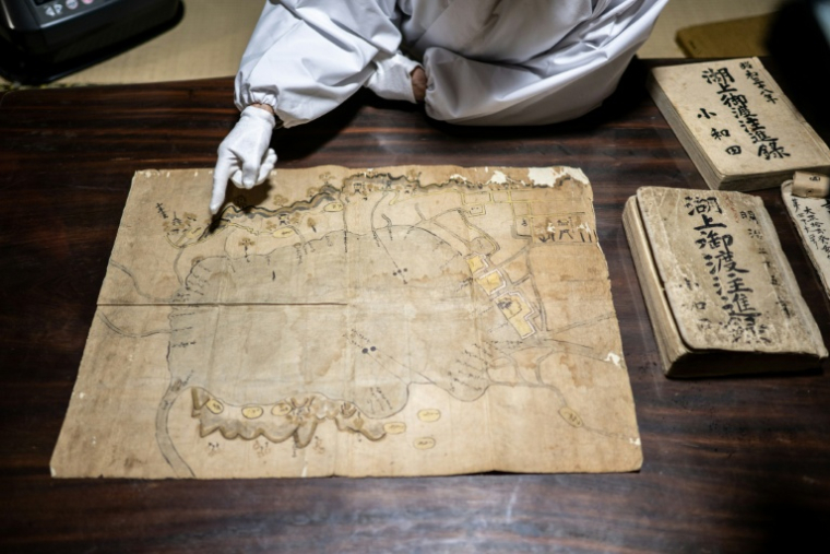 Kiyoshi Miyasaka, prêtre japonais du culte shinto, montre une très ancienne carte, le 29 janvier 2026 à Suwa, dans la préfecture de Nagano, dans le centre de l'archipel ( AFP / Philip FONG )