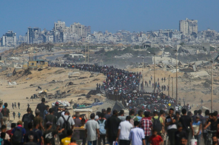 Des Palestiniens marchent le long de la route côtière Al-Rachid dans le centre de la bande de Gaza en direction de la ville de Gaza, dans le nord, le 10 octobre 2025 ( AFP / Bashar TALEB )