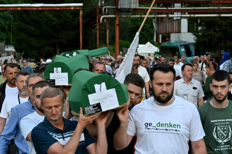 Des musulmans bosniaques portent des cercueils contenant les restes de victimes avant une cérémonie d'enterrement au cimetière commémoratif de Potocari, près de Srebrenica, dans l'est de la Bosnie, le 10 juillet 2025, à la veille du 30e anniversaire du génocide commis par les forces serbes de Bosnie ( AFP / Elvis BARUKCIC )