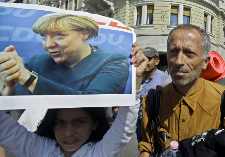 Des migrants à Budapest en route vers l'Autriche remercient Angela Merkel, alors chancelière allemande, le 4 septembre 2015 ( AFP / PETER KOHALMI )