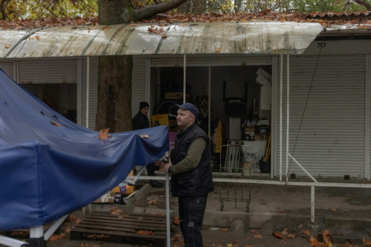 Kostiantyn, un vendeur de nourriture pour animaux,  s'apprêtent à fermer son étal, le 30 octobre 2026 à Kherson, dans le sud de l'Ukraine  ( AFP / Roman PILIPEY )