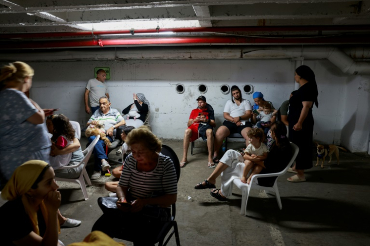 Des personnes sont réfugiées dans un parking à Tel-Aviv lors d'un nouveau tir de roquettes iraniennes, le 17 juin 2025 ( AFP / Menahem Kahana )