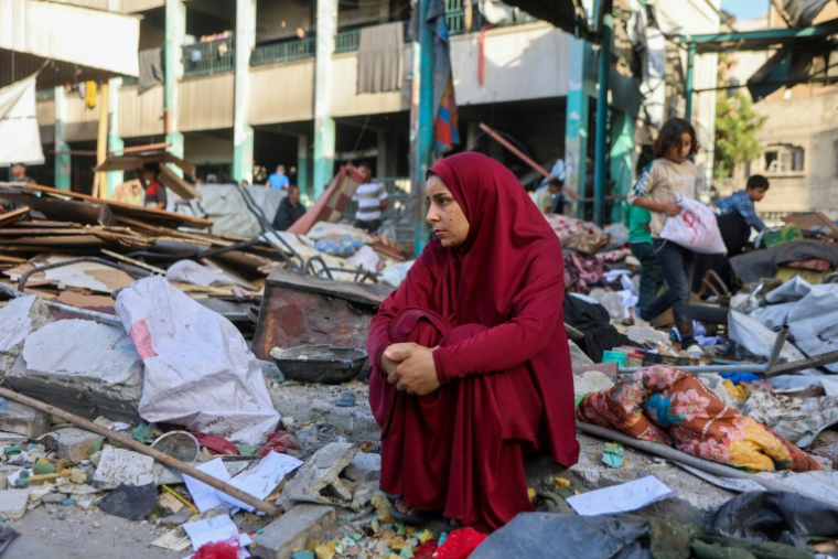 Une femme est assise au milieu des décombres après le bombardement d'une école à Gaza-ville, le 26 mai 2025 ( AFP / Omar AL-QATTAA )