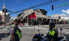 La police se rassemble devant un restaurant de fast-food Jollibee effondré après un séisme de magnitude 7,8 dans la ville de General Santos aux Philippines le 8 juin 2026 ( AFP / Edwin Espejo )