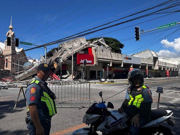 La police se rassemble devant un restaurant de fast-food Jollibee effondré après un séisme de magnitude 7,8 dans la ville de General Santos aux Philippines le 8 juin 2026 ( AFP / Edwin Espejo )